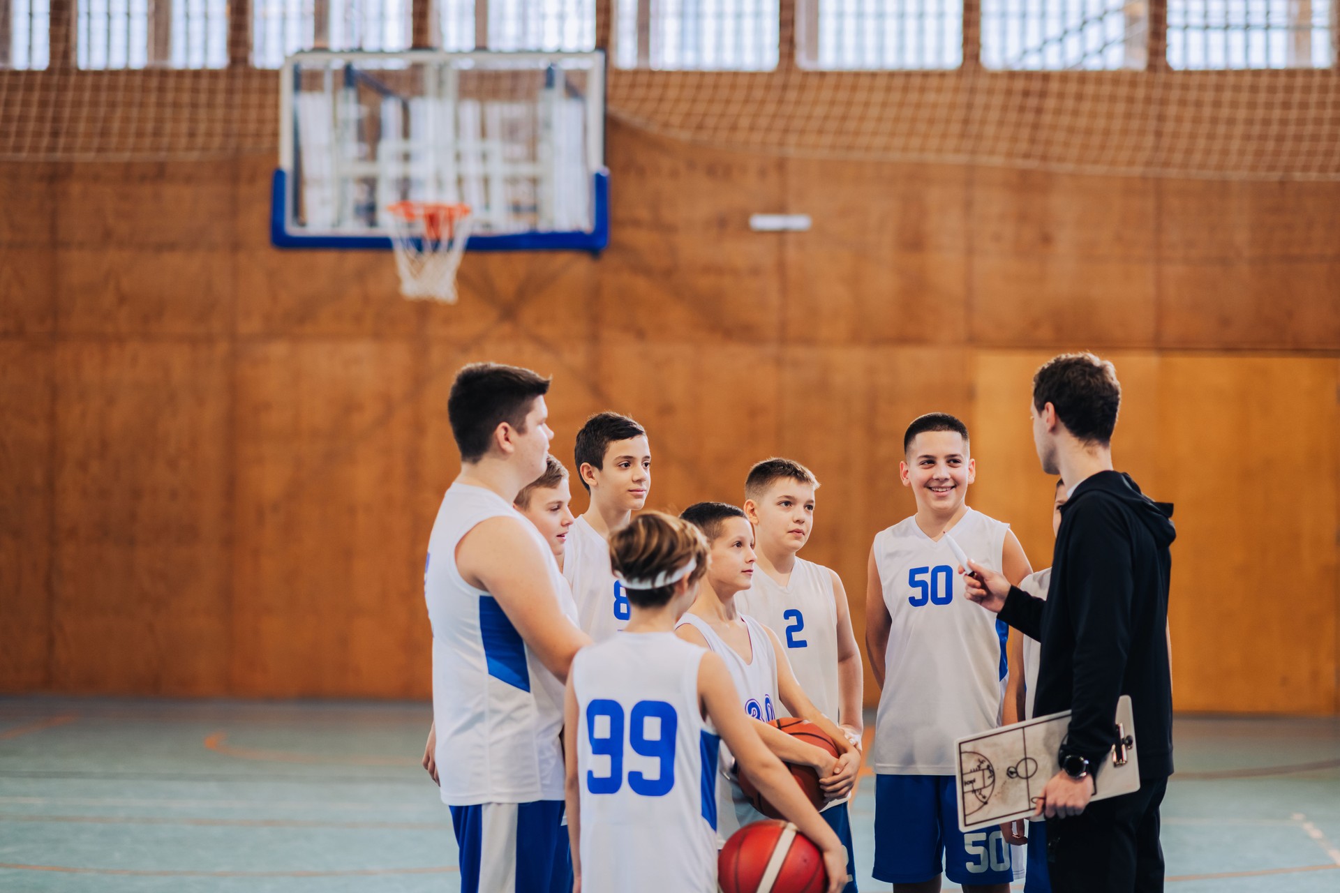 Basketball coach engaging with team during practice